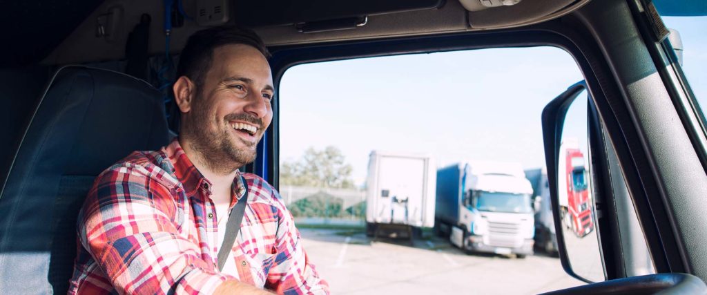 Smiling trucker driving in a parking lot